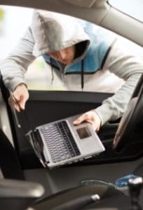 Thief stealing laptop from the car